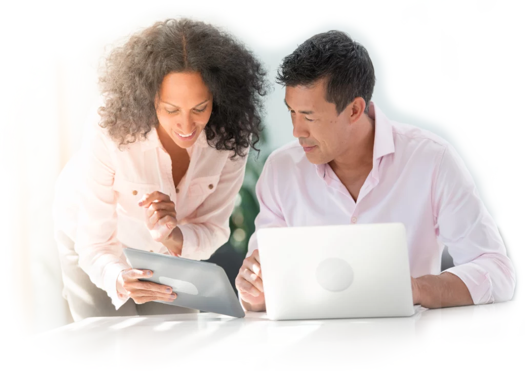 man and woman looking down while in front of laptop